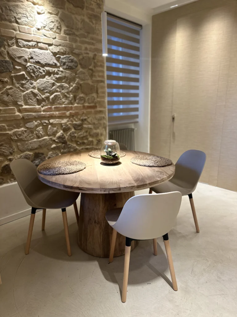 La zona pranzo con il tavolo tondo su tronco